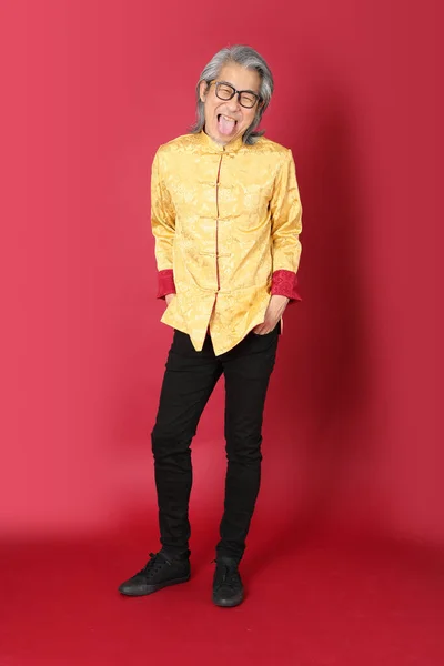 Kırmızı Arka Planda Duran Geleneksel Altın Rengi Çin Elbiseleri Giyen — Stok fotoğraf
