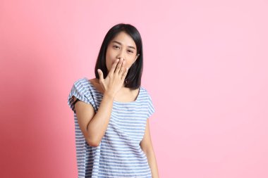 Pembe arka planda duran mavi gömlekli melez kadın..