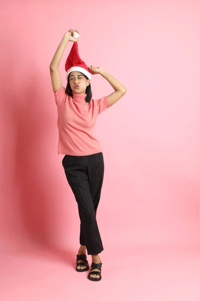 Pembe Arka Planda Duran Noel Baba Şapkası Giyen Melez Kız — Stok fotoğraf
