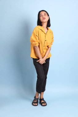 Mavi arka planda oturan melez kız portresi..