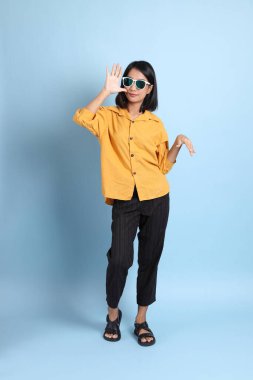 Mavi arka planda oturan melez kız portresi..