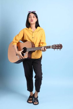 Mavi arka planda oturan melez kız portresi..