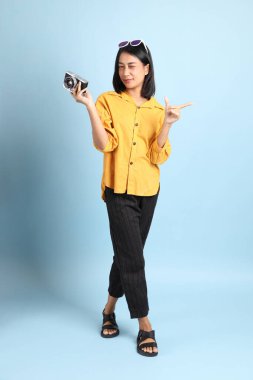 Mavi arka planda oturan melez kız portresi..