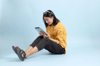 Mavi arka planda oturan melez kız portresi..