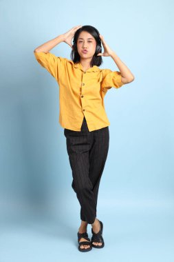 Mavi arka planda oturan melez kız portresi..