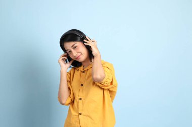 Mavi arka planda oturan melez kız portresi..