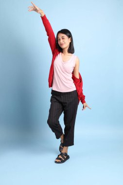 Mavi arka planda duran güzel Asyalı kadın..