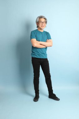 Mavi arka plandaki kıdemli Asyalı adam..