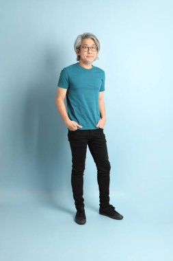 Mavi arka plandaki kıdemli Asyalı adam..