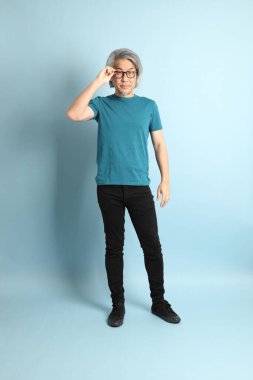 Mavi arka plandaki kıdemli Asyalı adam..