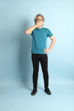 Mavi arka plandaki kıdemli Asyalı adam..