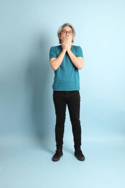 Mavi arka plandaki kıdemli Asyalı adam..