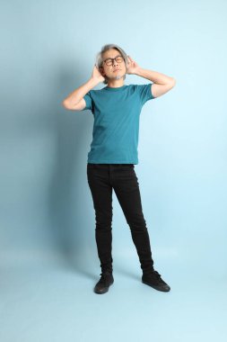 Mavi arka plandaki kıdemli Asyalı adam..