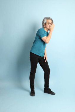 Mavi arka plandaki kıdemli Asyalı adam..