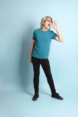 Mavi arka plandaki kıdemli Asyalı adam..