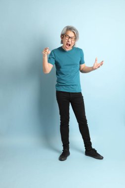 Mavi arka plandaki kıdemli Asyalı adam..