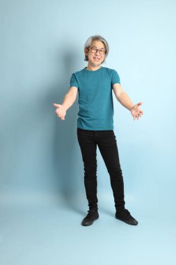 Mavi arka plandaki kıdemli Asyalı adam..