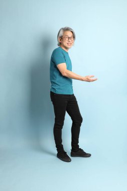 Mavi arka plandaki kıdemli Asyalı adam..