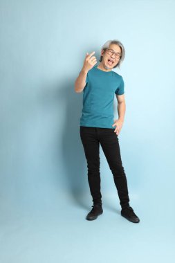 Mavi arka plandaki kıdemli Asyalı adam..