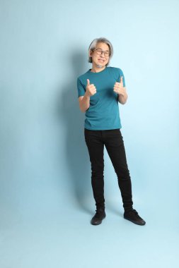 Mavi arka plandaki kıdemli Asyalı adam..