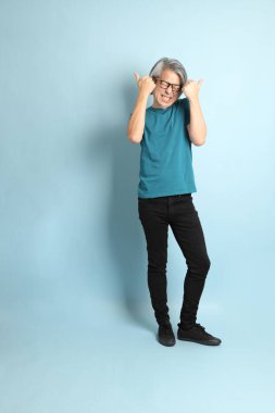 Mavi arka plandaki kıdemli Asyalı adam..