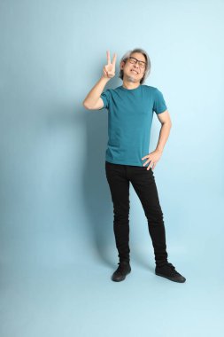 Mavi arka plandaki kıdemli Asyalı adam..