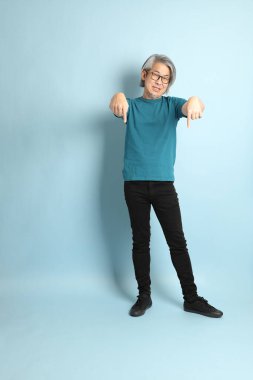 Mavi arka plandaki kıdemli Asyalı adam..