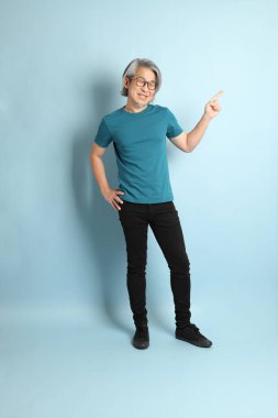 Mavi arka plandaki kıdemli Asyalı adam..