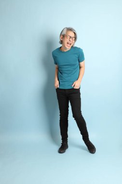 Mavi arka plandaki kıdemli Asyalı adam..