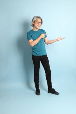 Mavi arka plandaki kıdemli Asyalı adam..