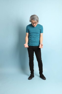 Mavi arka plandaki kıdemli Asyalı adam..