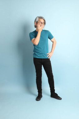 Mavi arka plandaki kıdemli Asyalı adam..