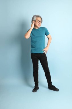 Mavi arka plandaki kıdemli Asyalı adam..