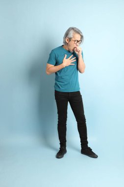 Mavi arka plandaki kıdemli Asyalı adam..