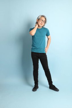 Mavi arka plandaki kıdemli Asyalı adam..