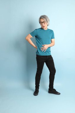 Mavi arka plandaki kıdemli Asyalı adam..