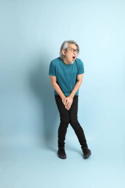 Mavi arka plandaki kıdemli Asyalı adam..