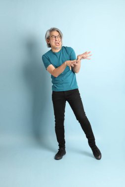 Mavi arka plandaki kıdemli Asyalı adam..