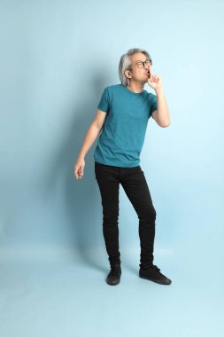 Mavi arka plandaki kıdemli Asyalı adam..