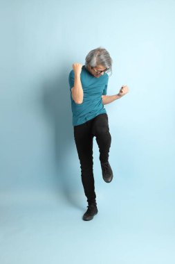 Mavi arka plandaki kıdemli Asyalı adam..