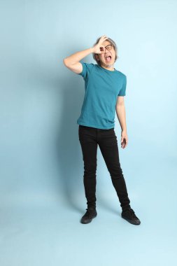 Mavi arka plandaki kıdemli Asyalı adam..