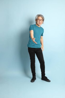 Mavi arka plandaki kıdemli Asyalı adam..