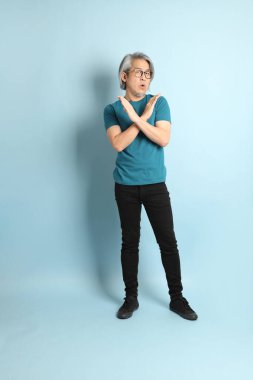 Mavi arka plandaki kıdemli Asyalı adam..