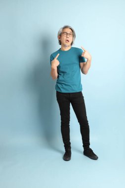 Mavi arka plandaki kıdemli Asyalı adam..