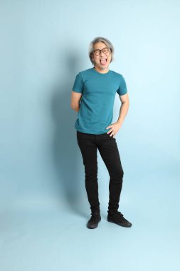 Mavi arka plandaki kıdemli Asyalı adam..