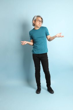 Mavi arka plandaki kıdemli Asyalı adam..