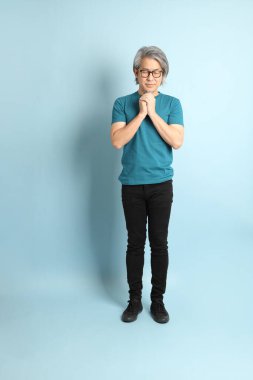 Mavi arka plandaki kıdemli Asyalı adam..