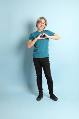 Mavi arka plandaki kıdemli Asyalı adam..