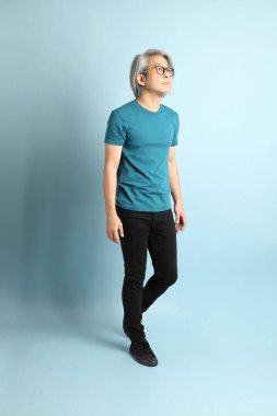 Mavi arka plandaki kıdemli Asyalı adam..