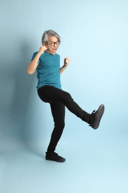 Mavi arka plandaki kıdemli Asyalı adam..